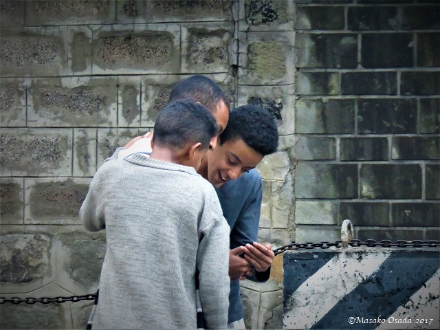 Three boys looking at a smartphone
