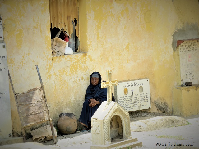 Old woman sitting in shade
