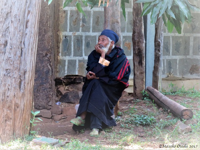 Priest in green plastic shoes