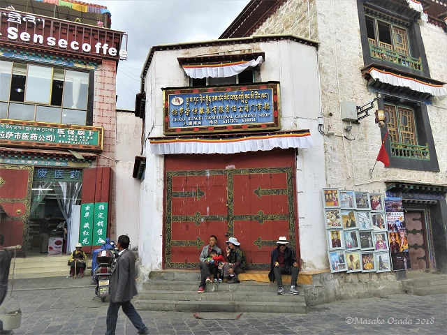 Family in front of traditional garment shop, Octagon Street, Lhasa, Tibet, September 2018