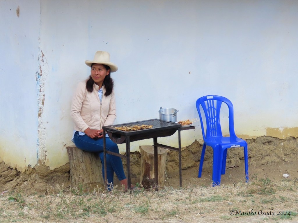 Young woman selling skewered grilled meat. Cruz Pata